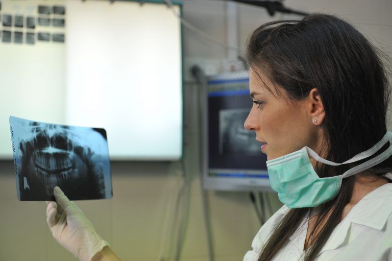 A clinician examining a panoramic dental X-ray