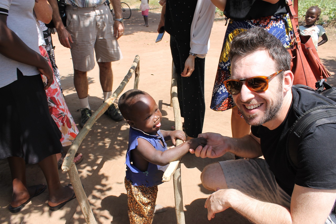 A Rambam volunteer greeting a young child during a Uganda mission