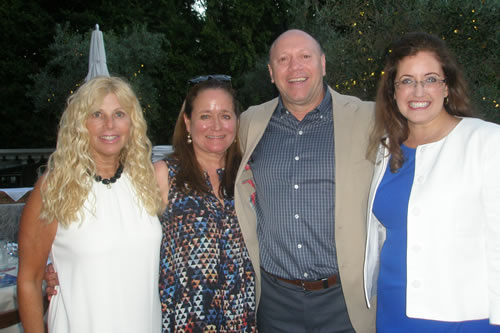 Four guests at an outdoor evening reception