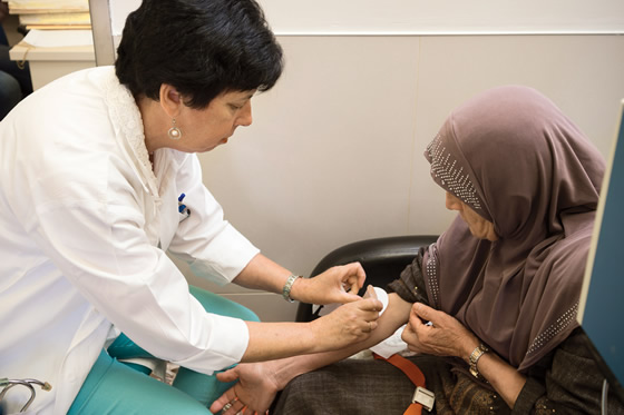 A nurse caring for an elderly woman at a Rambam clinic
