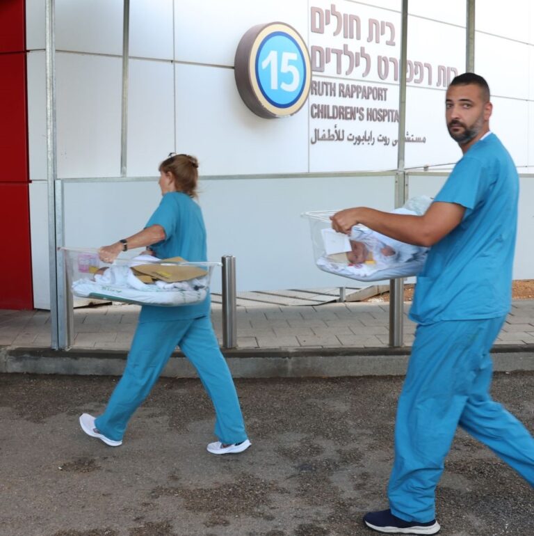 Staff carrying newborns in carriers during the move underground