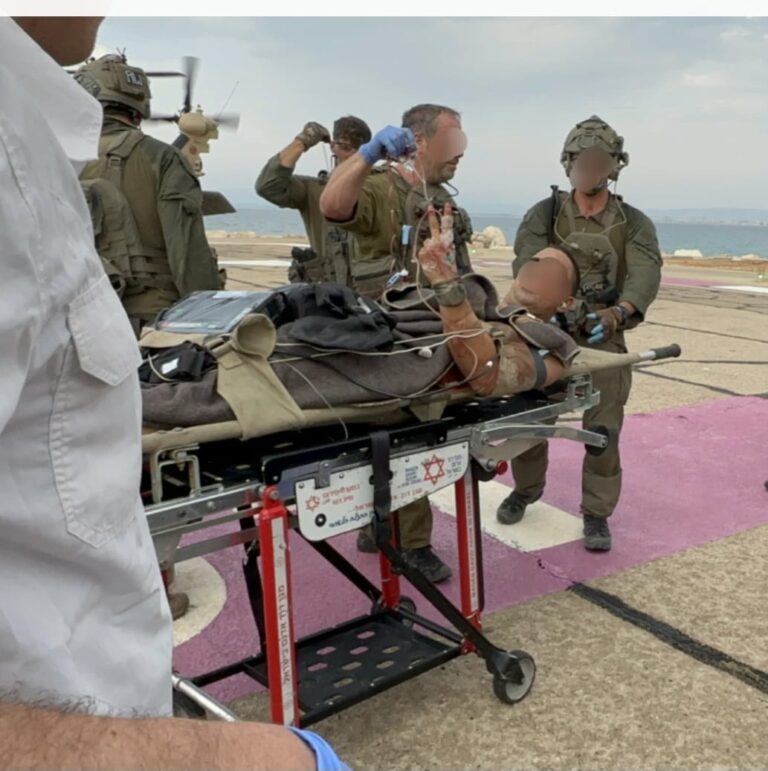 Soldiers transferring a wounded comrade from a helicopter to Rambam